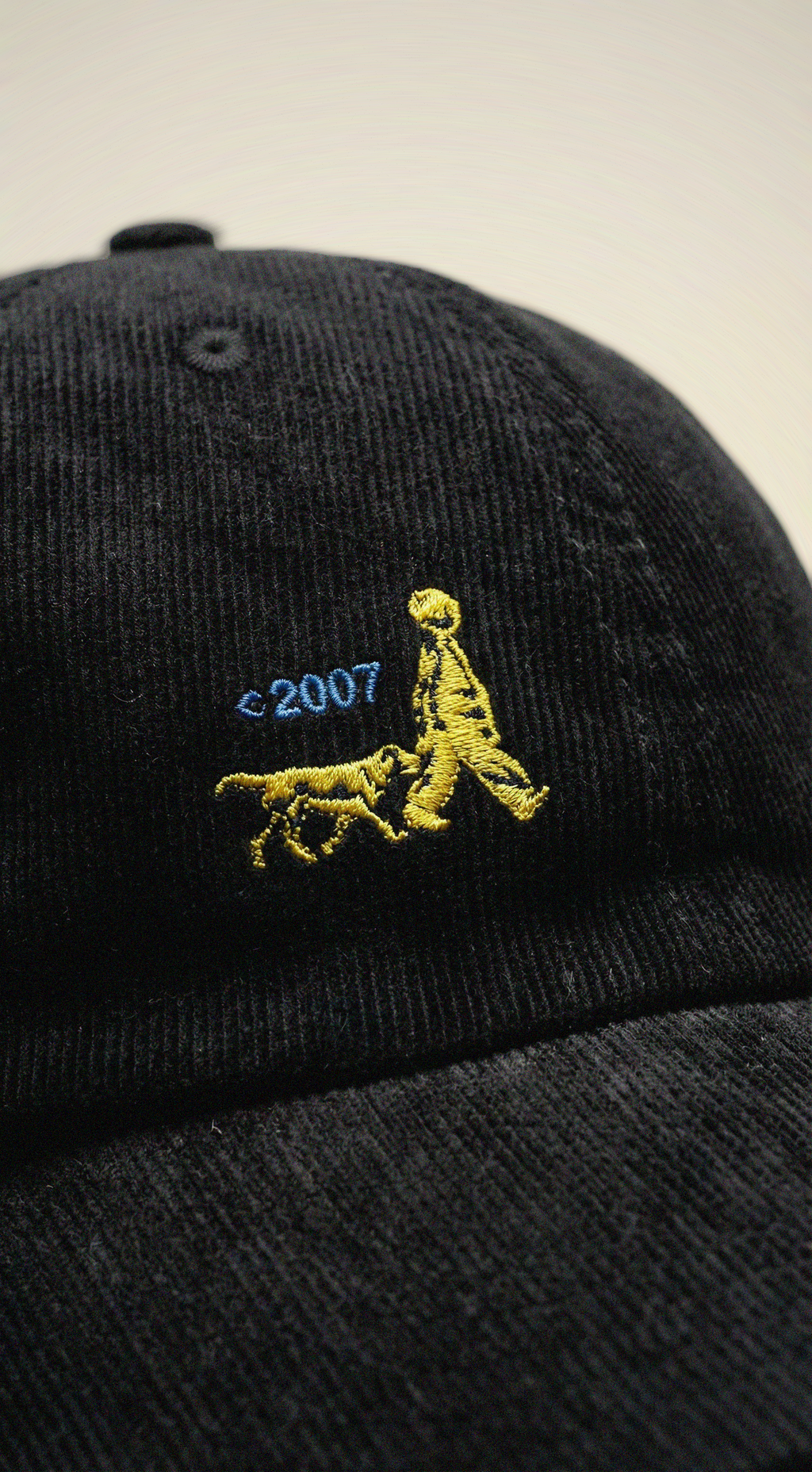 A black cap with a logo of a child and a dog