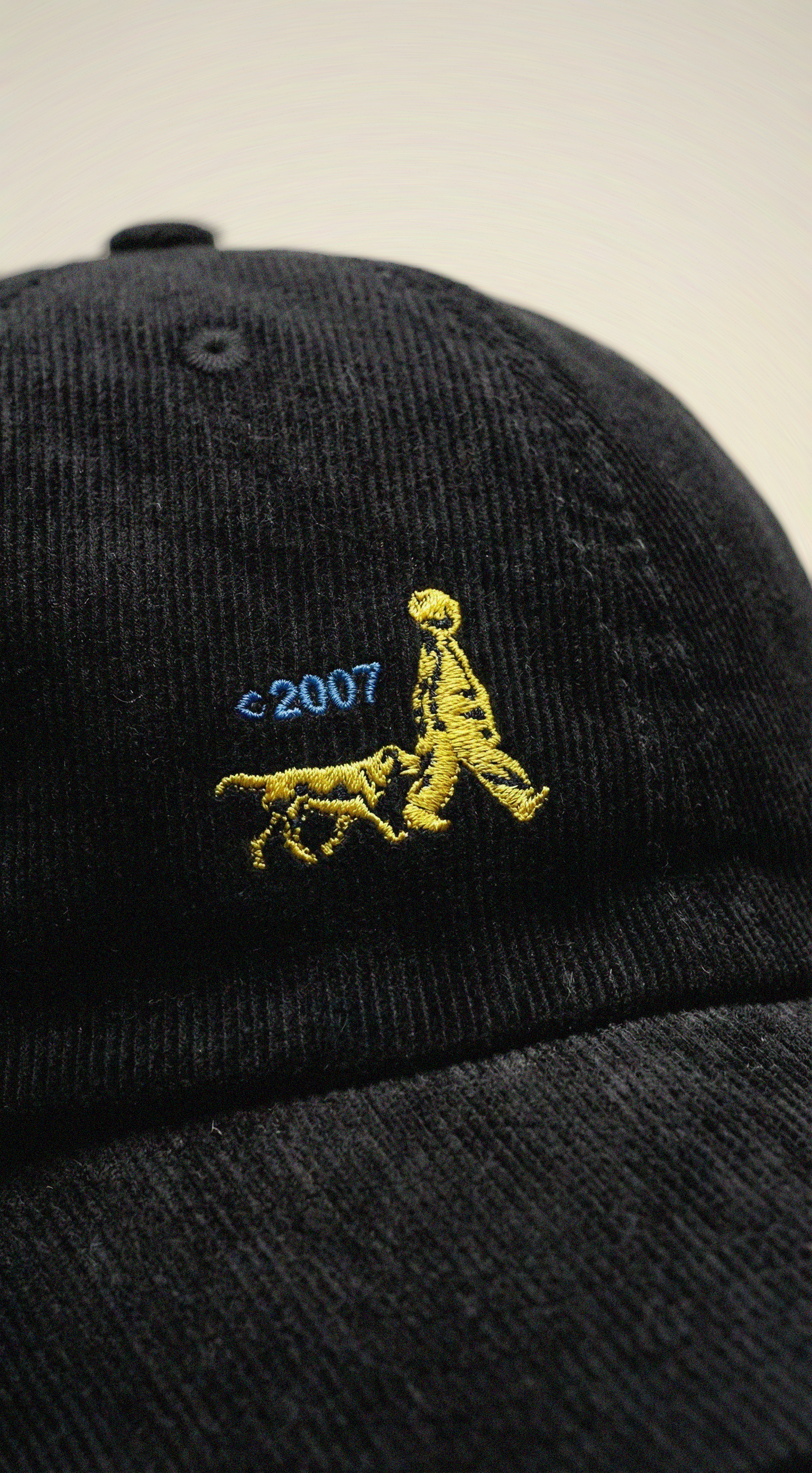 A black cap with a logo of a child and a dog