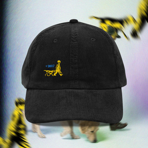 Black cap with yellow logo of a child and a dog on a blurred background