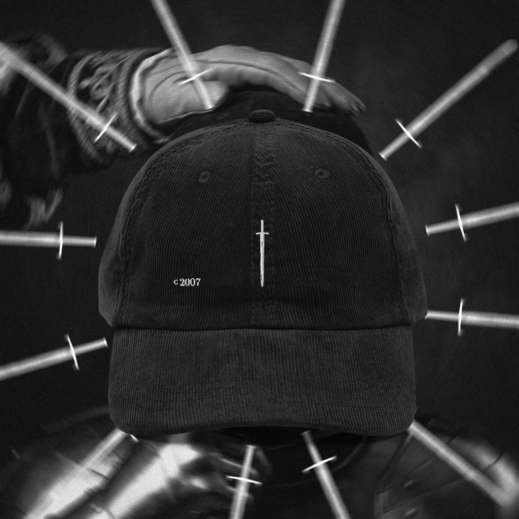 Black cap with a small white sword logo on a blurred background