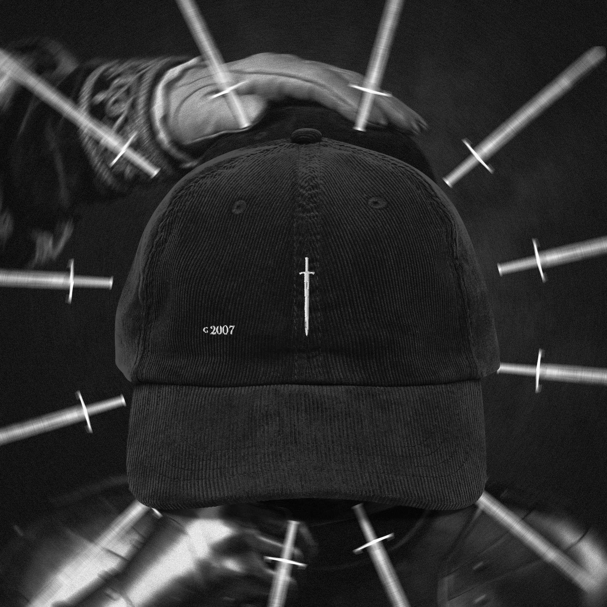 Black cap with a small white sword logo on a blurred background