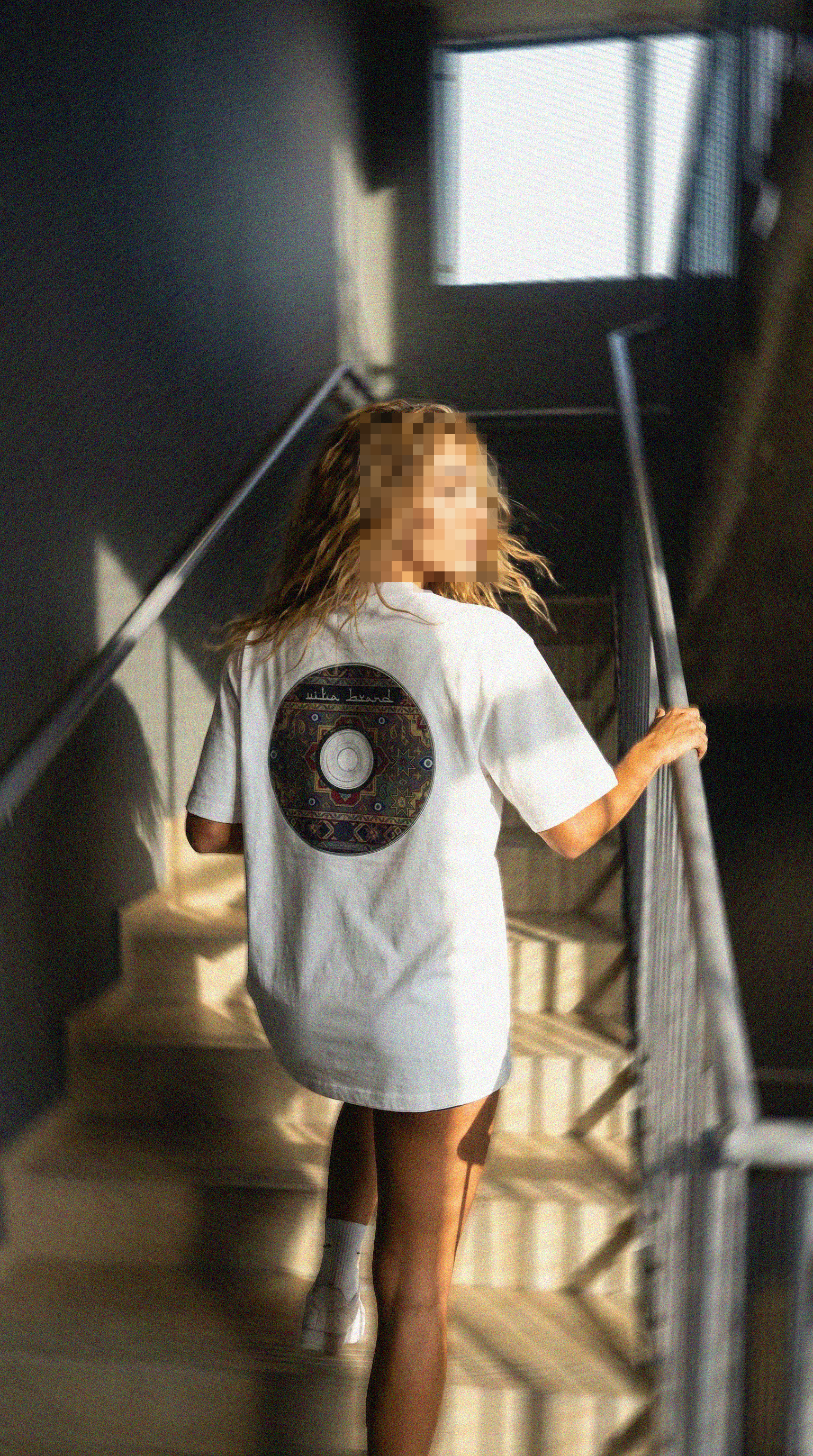 A beautiful blonde woman with mosaic face wearing a white t-shirt with a turkish carpet CD logo that reads: "Vita Brand" running up the stairs in an action pose